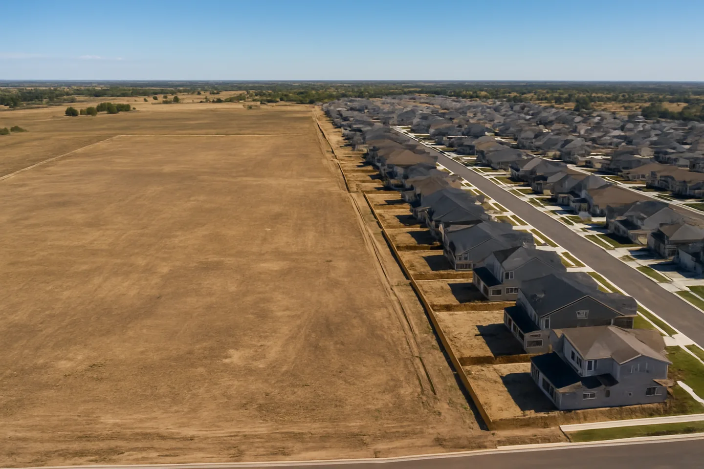 Aerial view of undeveloped land next to new construction